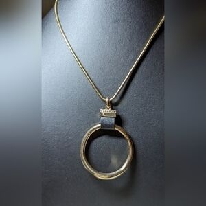 A Macy's golden pendant on a golden chain with crystal detail.NWT